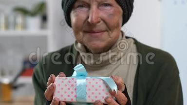 微笑的无家可归的女人拿着礼盒，看着镜头，惊喜